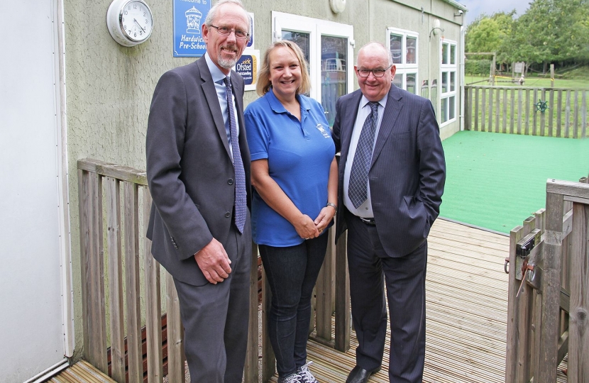 Simon Edwards, Finance and Staffing Portfolio Holder of South Cambridgeshire District Council, Sharon Griffiths, Manager of Hardwick Pre-School and Grenville Chamberlain, District Councillor for Hardwick.  They are on the new decking outside the Tardis-like pre-school building.