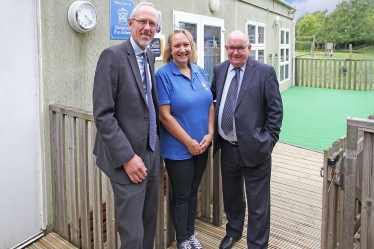 Simon Edwards, Finance and Staffing Portfolio Holder of South Cambridgeshire District Council, Sharon Griffiths, Manager of Hardwick Pre-School and Grenville Chamberlain, District Councillor for Hardwick.  They are on the new decking outside the Tardis-like pre-school building.